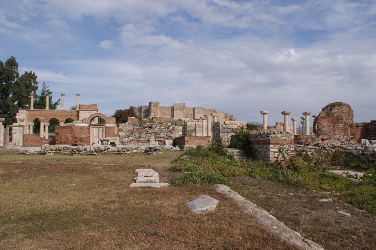 Ruins of the Basilica of Saint John with rebuilt brick arcades and marble columns, the walls and towers of Ayasuluk Fortress on the hill behind