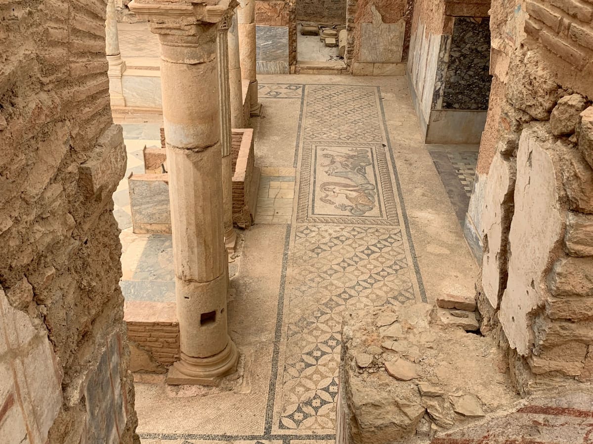 A columned courtyard in the Terrace Houses of Ephesus, with brick arches and a patterned mosaic floor